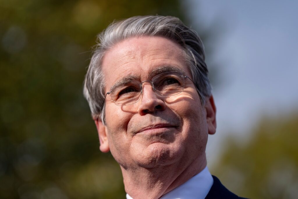 USA:s finansminister Scott Bessent utomhus med glasögon och kostym mot suddig bakgrund